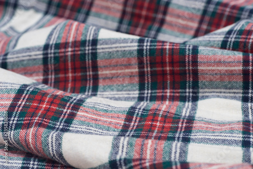 folded creased multicolored checkered woolen fabric background © aga7ta