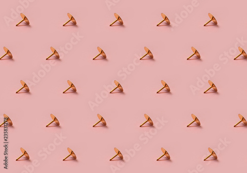 Golden tack pattern on pink background