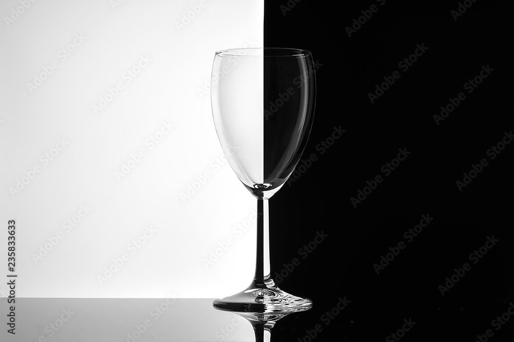 Empty glass of wine on white and black background close-up.