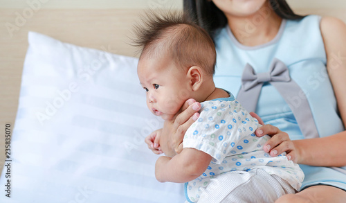 Tableau sur toile Health care after meal. Mother is belching for infant baby.