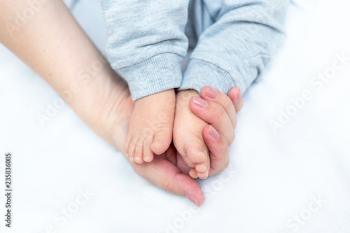 mother is holding feet of her newborn baby