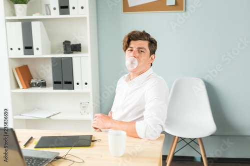 Fotografie Joke, office, humor, people concept - handsome man chewing gum and thinking abou