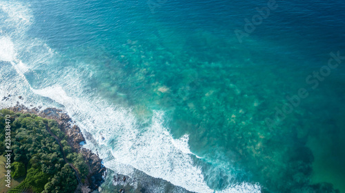 Aerial flying drone view of indian ocean on sunny tropical paradise island with aqua blue sea water