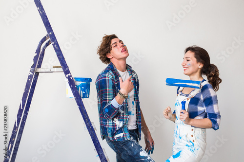Renovation, repair and family concept - a young couple doing a repair in new home