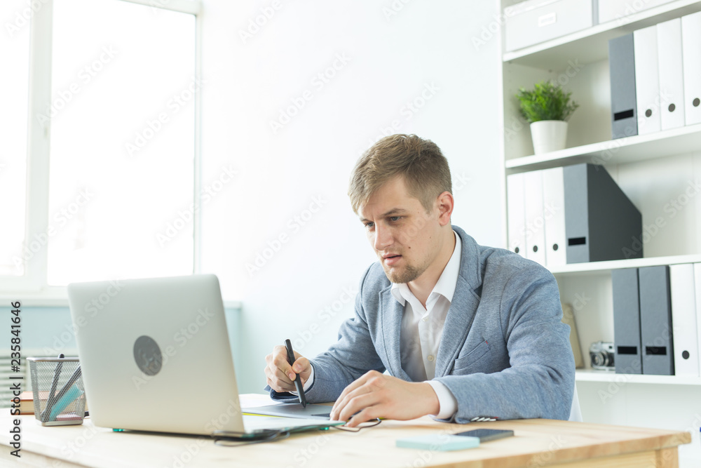 Designer, artist and web design concept - Portrait of young man using digital pen tablet and laptop in the office Designer, artist and web design concept - Portrait of young man using digital pen tablet and laptop in the office