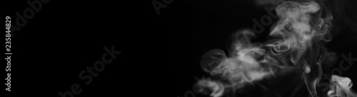 White smoke on a black background. Texture of smoke. Clubs of white smoke on a dark background for an overlay