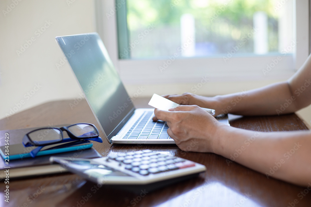 Hand women shoping online by notebook on desk about at coffee shop. shoping online concept Hand women shoping online by notebook on desk about at coffee shop. shoping online concept