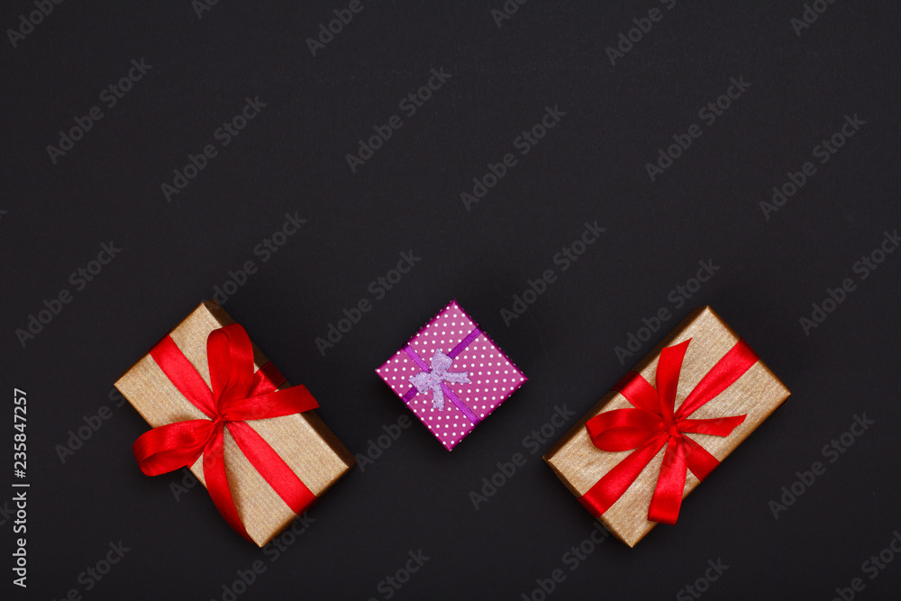 Gift boxes with ribbons on black background.
