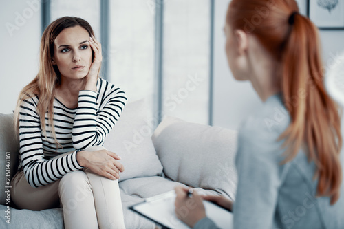 Foto Sad business woman consulting psychiatrist about her eating disorder problems during session in office