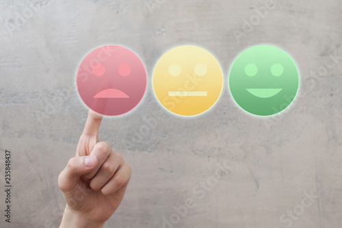 Finger rating with sad neutral happy face icons by pressing red button on virtual interface. Customer satisfaction service quality online evaluation and survey. Negative feedback concept.