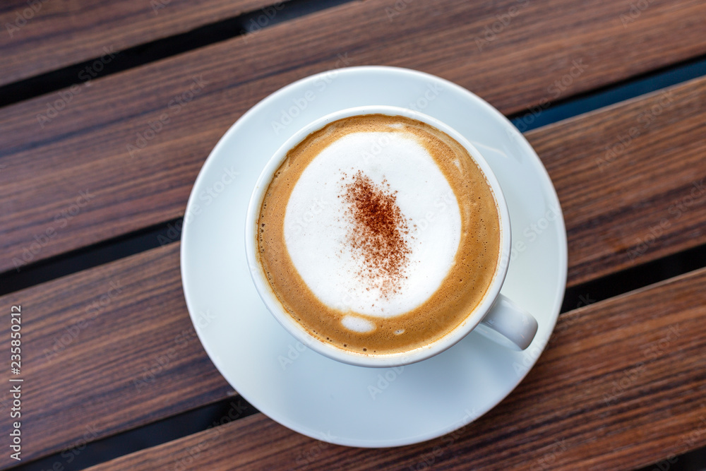 Cappuccino coffee with bubbles in wooden tray, black background. Cappuccino coffee with bubbles in wooden tray, black background.