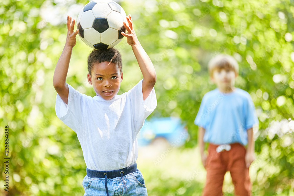 Afrikanischer Junge balanciert mit Fußball Afrikanischer Junge balanciert mit Fußball