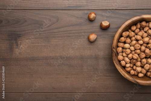 photo of a bowl full of hazelnuts on the brown wooden table