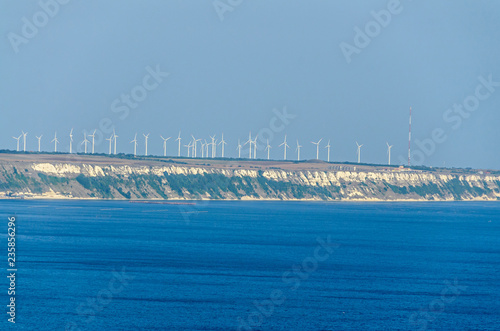 Thracian cliffs near blue clear water of Black Sea, wind farm