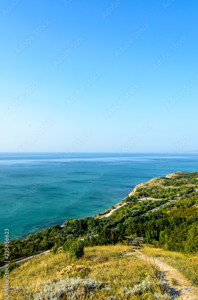 Green Thracian cliffs near blue clear water of Black Sea, bulgarian coastline with hotels and golf terrain