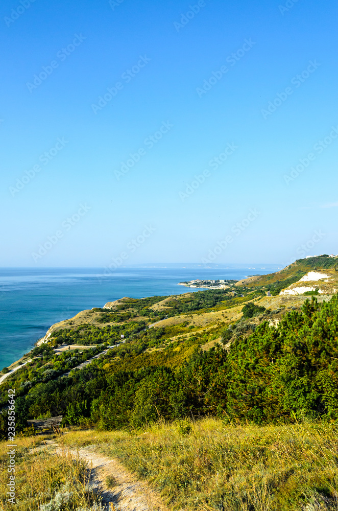 Green Thracian cliffs near blue clear water of Black Sea, bulgarian coastline with hotels and golf terrain