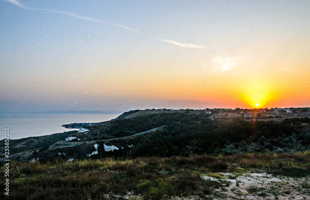 Green Thracian cliffs near blue clear water of Black Sea, sunset path seaview