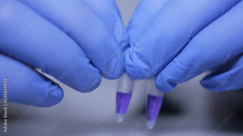 Close up of hands of scientist in gloves holding pipette and pouring solutions into test tube. GMO. DNA. Medical worker . Student used laboratory vessels in experiments. Work in the laboratory