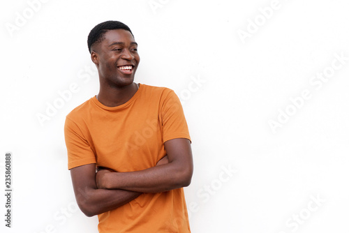 smiling young african american man with arms crossed and t shirt against isolated white background