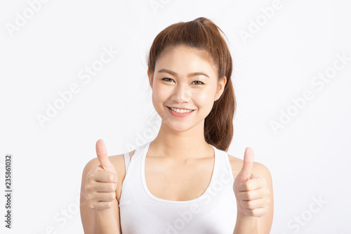 Beautiful Attractive Asian woman smile and showing thumbs up for good hand sign feeling so happiness and confident,Isolated on white background,Beauty concept