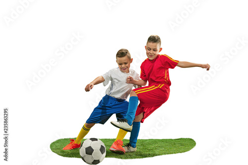 Young boys with soccer ball doing flying kick, isolated on white. football soccer players in motion on studio background. Fit jumping boys in action, jump, movement at game.