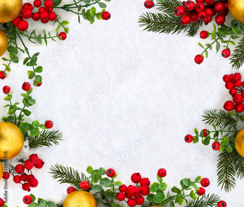 Christmas decoration. Frame of twigs christmas tree, christmas yellow balls and red berries on snow with space for text. Top view, flat lay