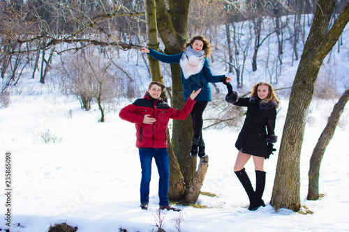 group of friends having fun in the park in winter near the river