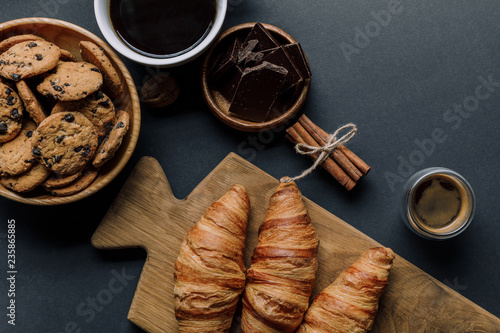 view from above of cinnamon, coffee, croissants, chocolate and cookies on black table © LIGHTFIELD STUDIOS