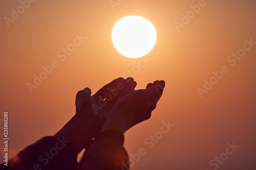 Woman with praying arms enjoying the sunrise / sunset time.