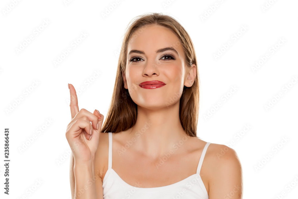 Portrait of young beautiful happy woman pointing up on white background Portrait of young beautiful happy woman pointing up on white background