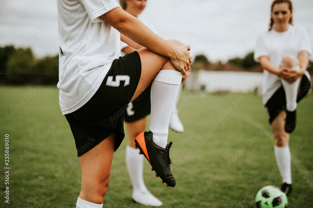 Female soccer team players stretching pre game