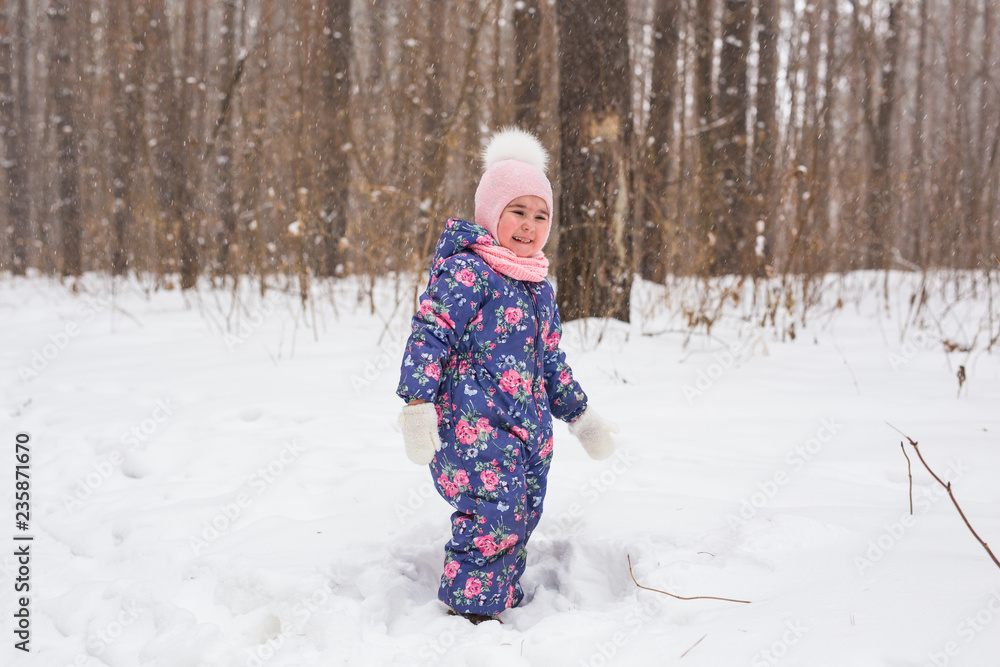 Family, children and nature concept - Beautiful little child girl have fun in winter park Family, children and nature concept - Beautiful little child girl have fun in winter park