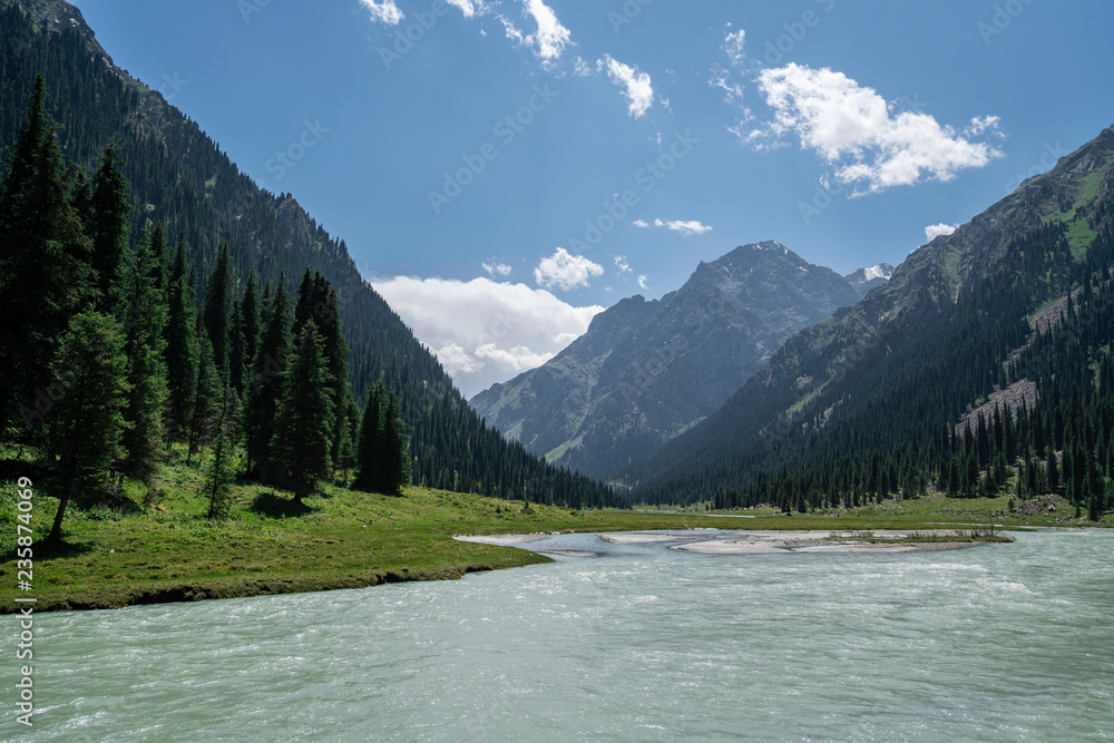 Horses resting at a river in a valley in Kyrgyzstan