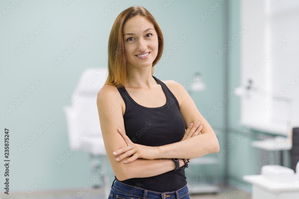 Portrait of young girl owner of beauty salon for nail care and hands with arms crossed, background beauty salon