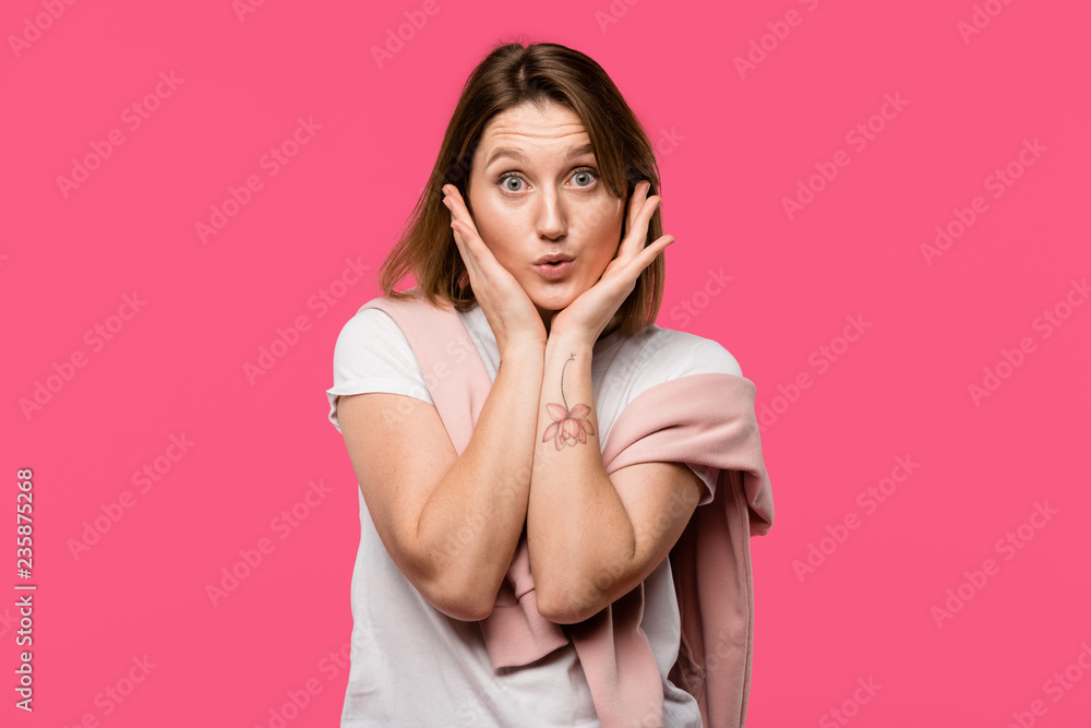 attractive girl looking at camera with hands on cheeks isolated on pink attractive girl looking at camera with hands on cheeks isolated on pink