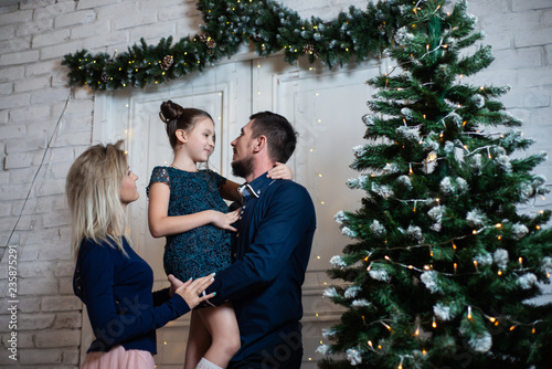 Christmas photo of happy family with gift boxes on background of decorated Christmas tree. Family celebrates New year © Vladimir