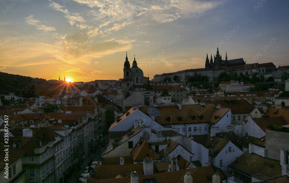 Prague, Czech Republic, September 19, 2018. Beautiful view from above on the city, red roofs of houses, Prague Castle and church in Mala Strana at sunset