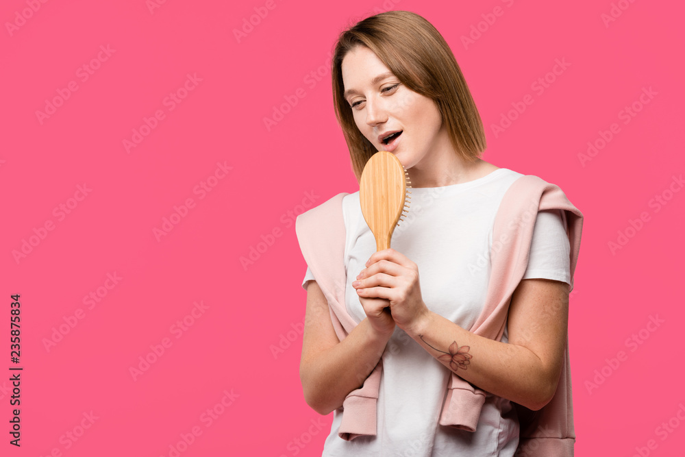 beautiful girl holding hairbrush and singing isolated on pink beautiful girl holding hairbrush and singing isolated on pink