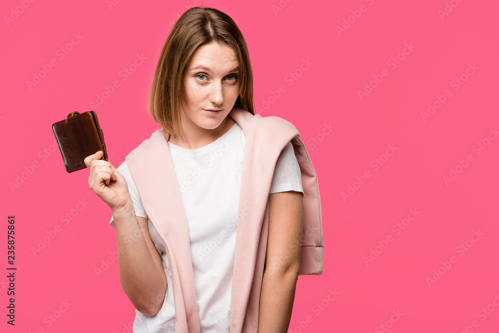 young woman holding wallet and looking at camera isolated on pink young woman holding wallet and looking at camera isolated on pink