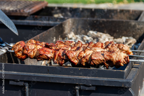 Grilled kebab cooking on metal skewer. Roasted meat cooked at barbecue