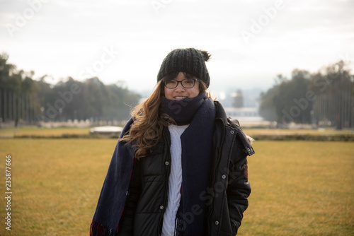 A portrait of a young Asian Australian woman standing in front of the Old Parliament House  and Mt Ainslie in the early morning in winter, Canberra, Australia.