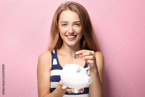 Young woman putting coin in...