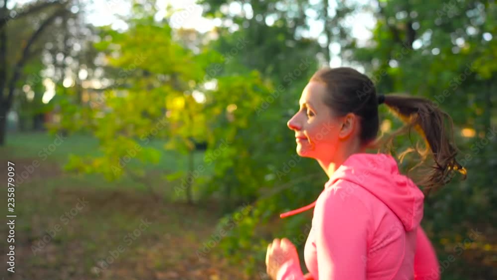 Close up of woman running through an autumn park at sunset. Slow motion Close up of woman running through an autumn park at sunset. Slow motion