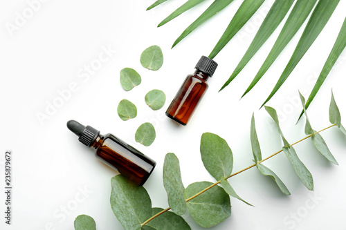 Bottles of eucalyptus essential oil on white background