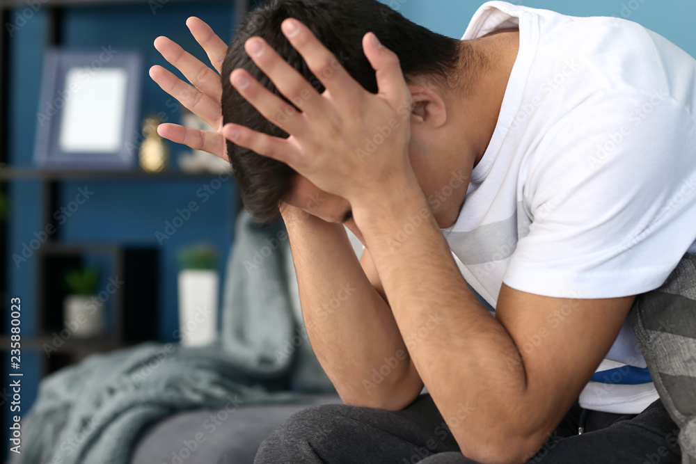 Young man suffering from headache at home Young man suffering from headache at home