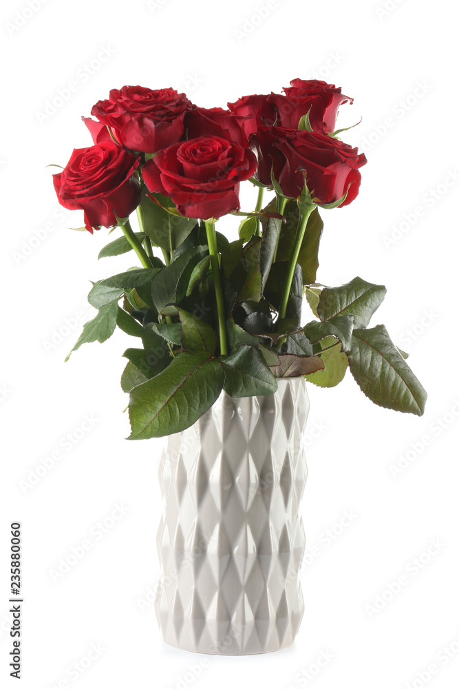 Obraz premium Beautiful bouquet of red roses in ceramic vase on white background