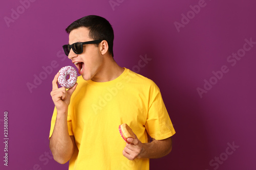 Young man with tasty donuts...