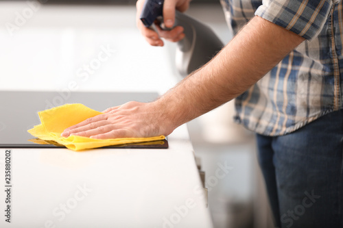 Young man cleaning kitchen
