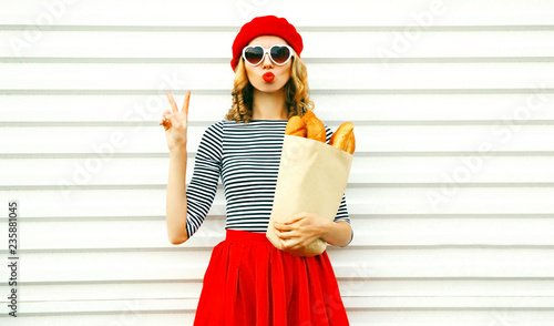 Fotografiet Portrait pretty cool girl wearing french red beret holding paper bag with long w