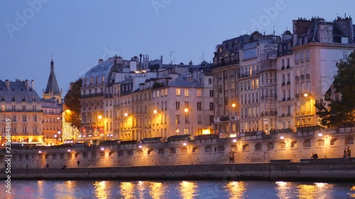 View on the Seine river, in the night. Filmed in the saint-michel disctrict in the center of Paris, France. People are walking on the quays. photo